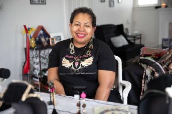 A business owner sits at a table with their wares. 