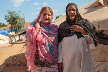 A mother and daughter posing for the camera.