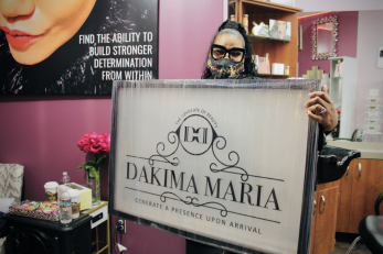 Dakima maria holds business sign