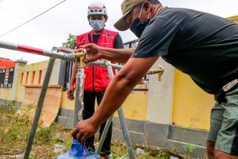 People filling a water jug.