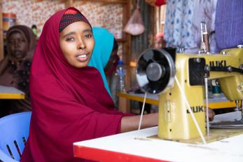 A person sitting at a sewing machine