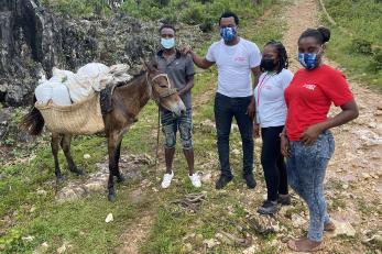 A farmer (left) with his donkey loaded with seeds he received from mercy corps.