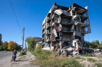 A parent and child pass damaged buildings in borodyanka, a settlement in the bucha region north of kyiv that was occupied by russian forces early in the war.