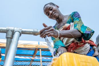 A person filling a jerry can with water.