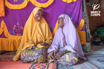A mother and daughter looking and smiling at each other.