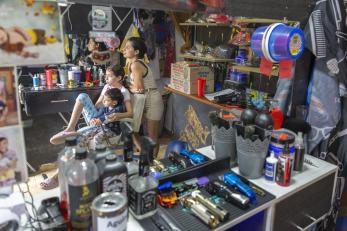 A family sitting together in a barbershop.