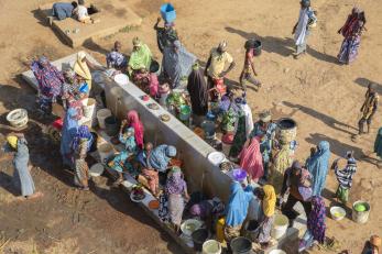 Herders and farmers commune at a water point, supported by a mercy corps peacebuilding program.
