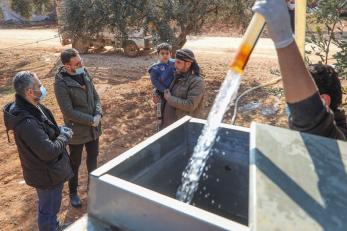 In a displacement camp in northwest syria, omar* and his father abdullah* watch as mercy corps refills their water tank with clean potable water. *names have been changed