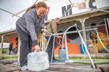 Woman filling up water container.