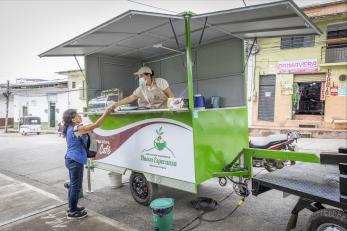 Employee and customer engaging at mobile coffee kiosk.