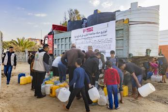 Gazans gather at a mercy corps water tender truck.