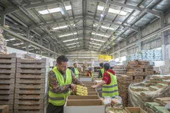 People packing food and supplies in a warehouse