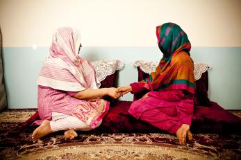 Two teenage girls facing each other while holding hands in afghanistan