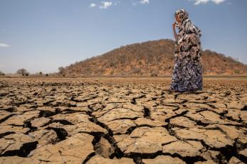 A person walking across dried earth.