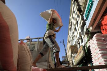 A yemeni worker carries a bag of flour outside a wholesale store in the capital sanaa.