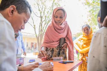A woman receives emergency cash assistance.