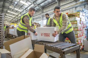 Mercy corps staff handling aid boxes in jordan