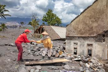 A mercy corps employee provides aid after a volcanic eruption in indonesia