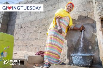 A woman operates a water tap.