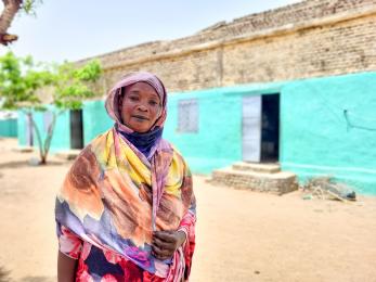 A woman poses outside a residence in sudan