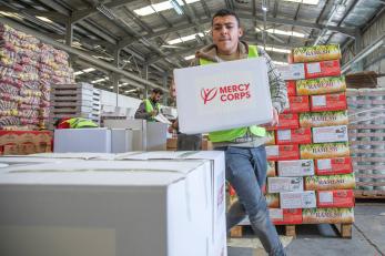 A man carries a mercy corps food kit in jordan
