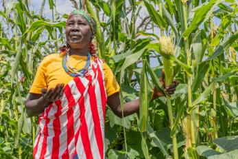 A woman poses aside corn crops in ethiopia