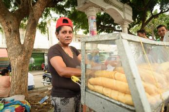 Yasmeli is pictured at her food stand wearing a backwards red cap