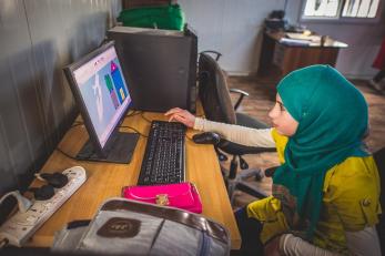 A young refugee using a computer at one of mercy corps' youth centers in zaatari refugee camp in jordan.