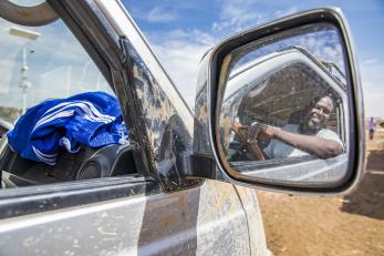 A smiling man reflected in the van's mirror