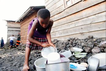 Girl in drc washing dishes