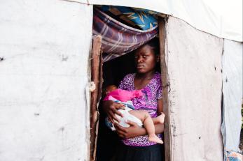 Mother holding a baby in a doorway