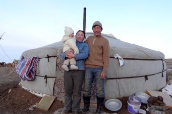 Bayraa and his wife urantaya (holding a baby) outside a yurt.
