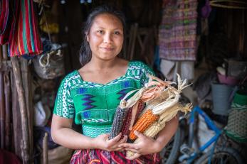 Guatemalan young woman holding corn she's harvested
