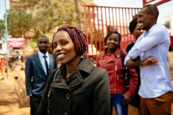 Zipporah smiling with several other people standing in background, also smiling