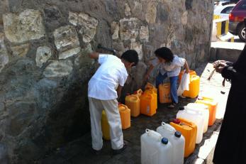 People filling water containers