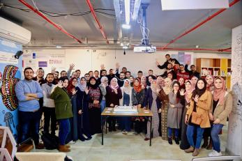 Group of young people all posing for the picture in their office place.