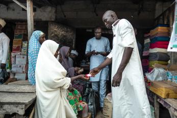 A sale in a market place using cash vouchers.