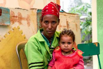 Mother with daughter sitting in her lap.