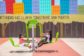 Sisters on a playground toy.