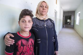 Iraqi mother and son in a hallway.