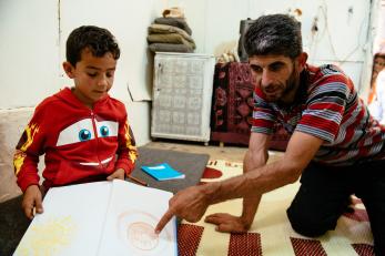 Ziad with a young boy, looking at a drawing