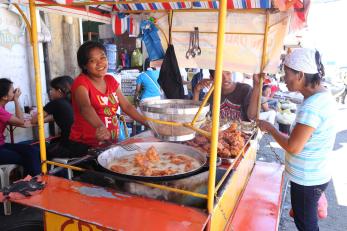 Filipino street food vendor and her customer 