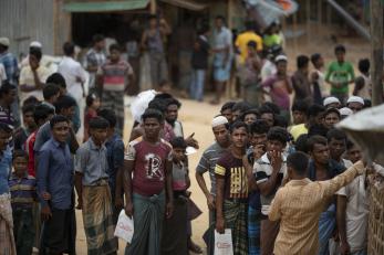Men and boys standing outside in a refugee camp in bangladesh