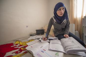 Amina pictured with textbooks and papers