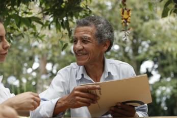 Man holding a folder and smiling at a woman