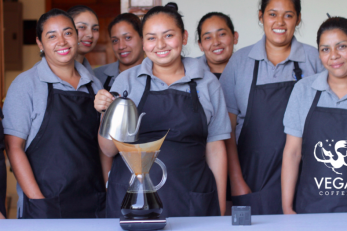 Group of women wearing vega aprons and one pouring water