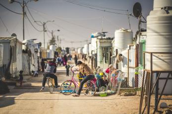 Boys at a refugee camp riding bicycles