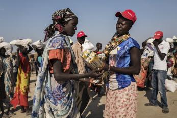 Mercy corps employee distributing aid.