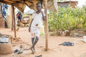 Young south sudanese boy outside a shelter