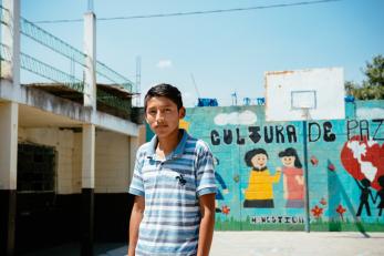 A boy in front of a basketball hoop in guatemala